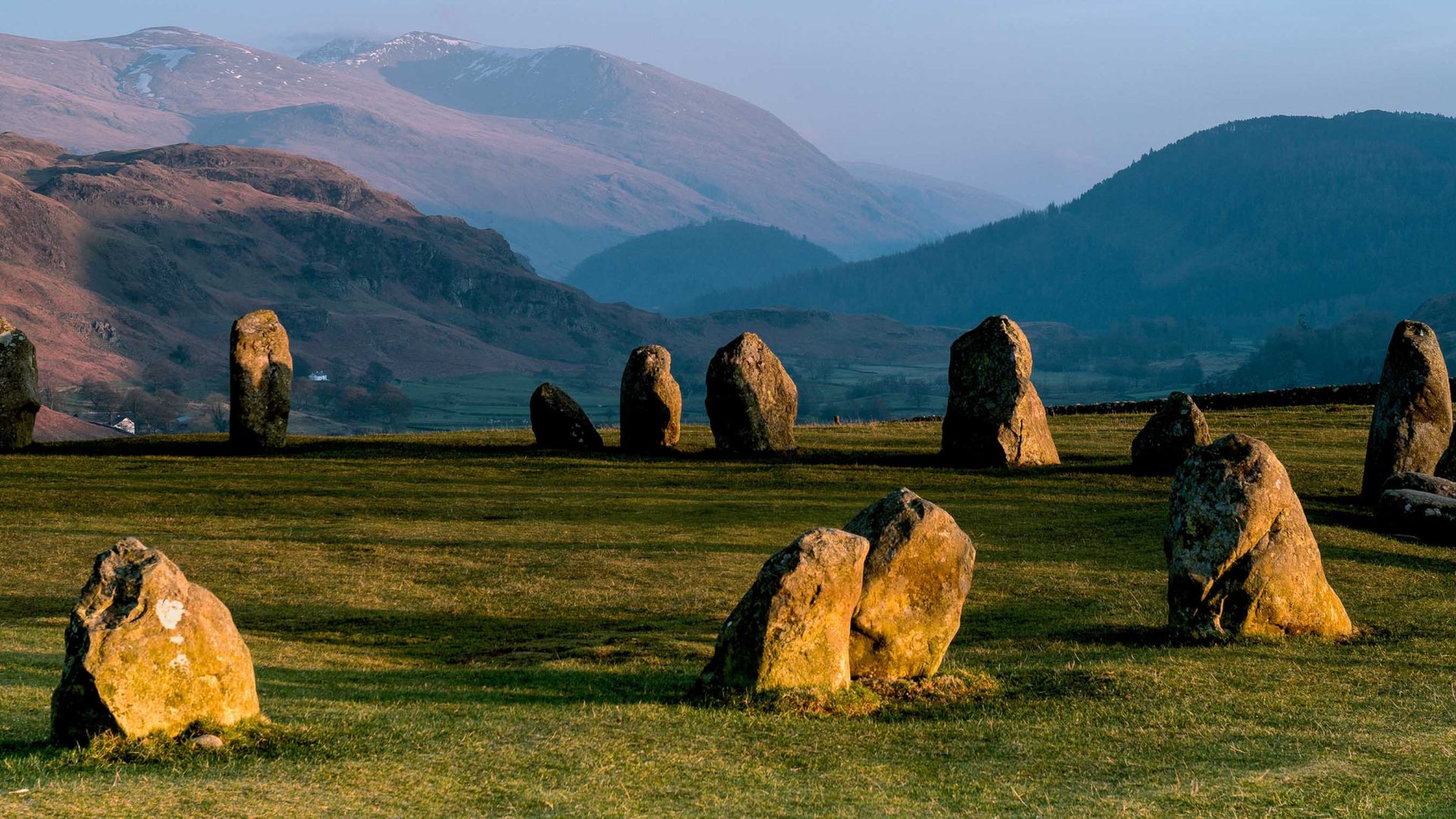 Rocks stick out of the ground in the foreground, while mountains are in the background.