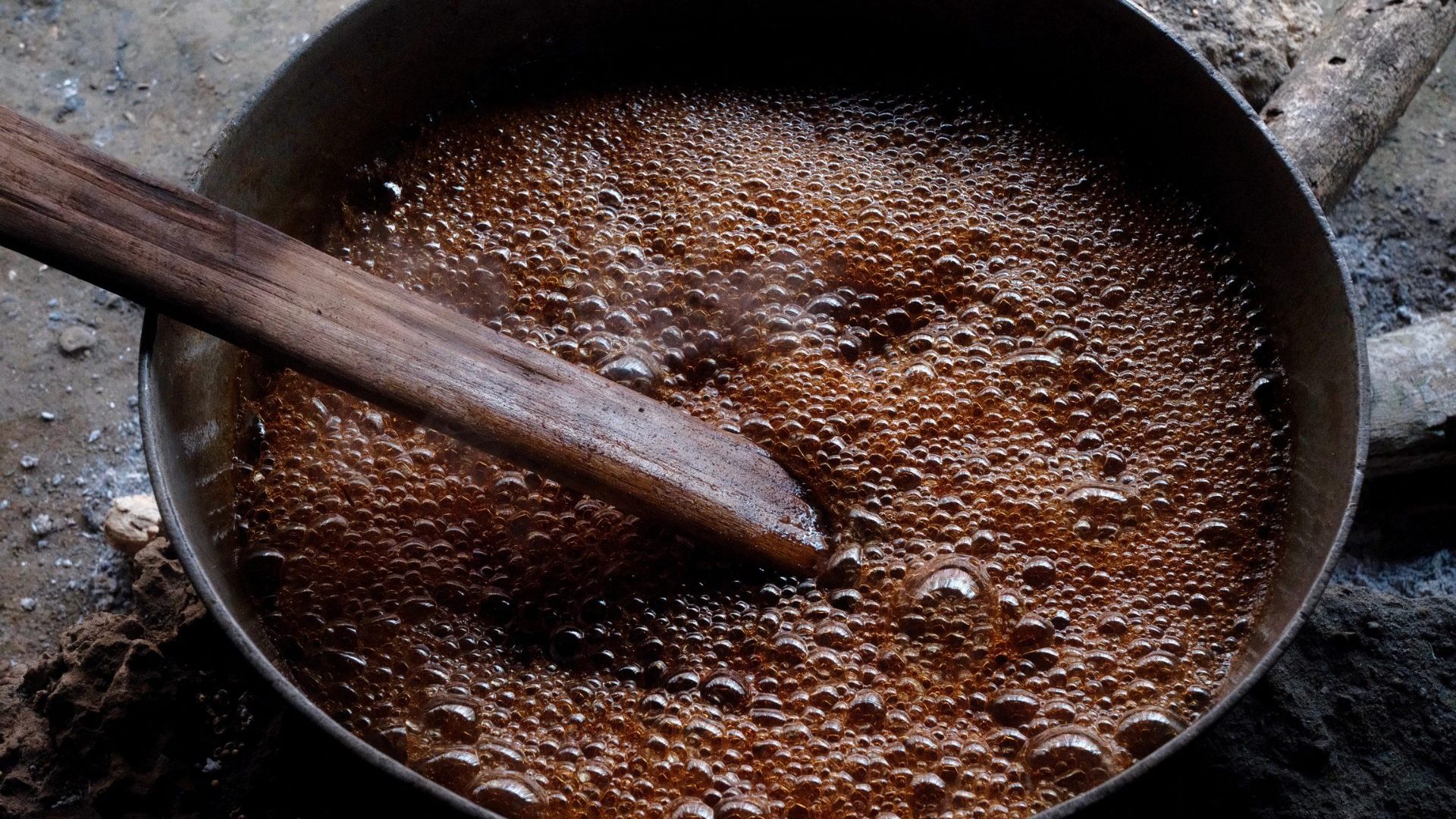 Brown liquid bubbles in black pot.