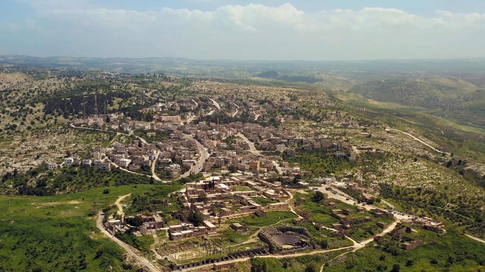Aerial image of Amman city—green grass, blue sky and light brown buildings