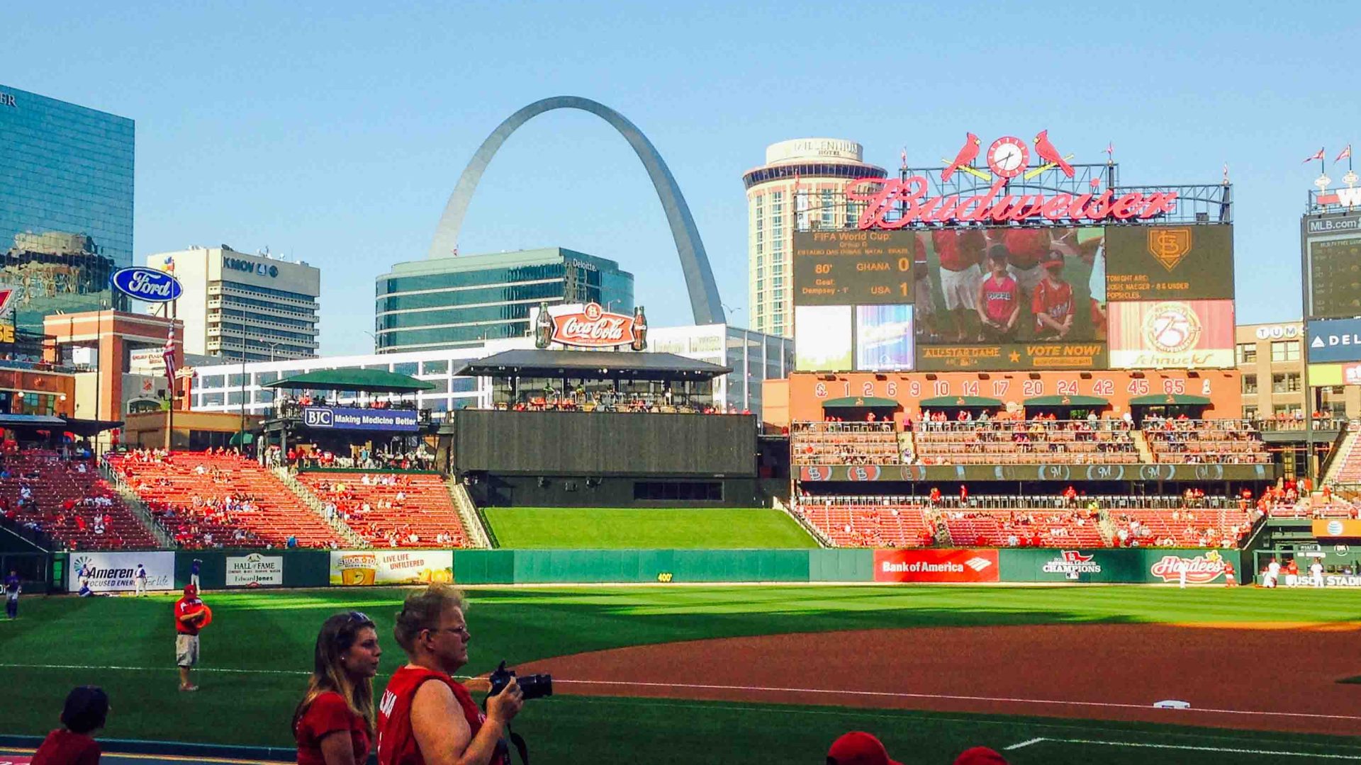 A baseball field with an arch in the background.