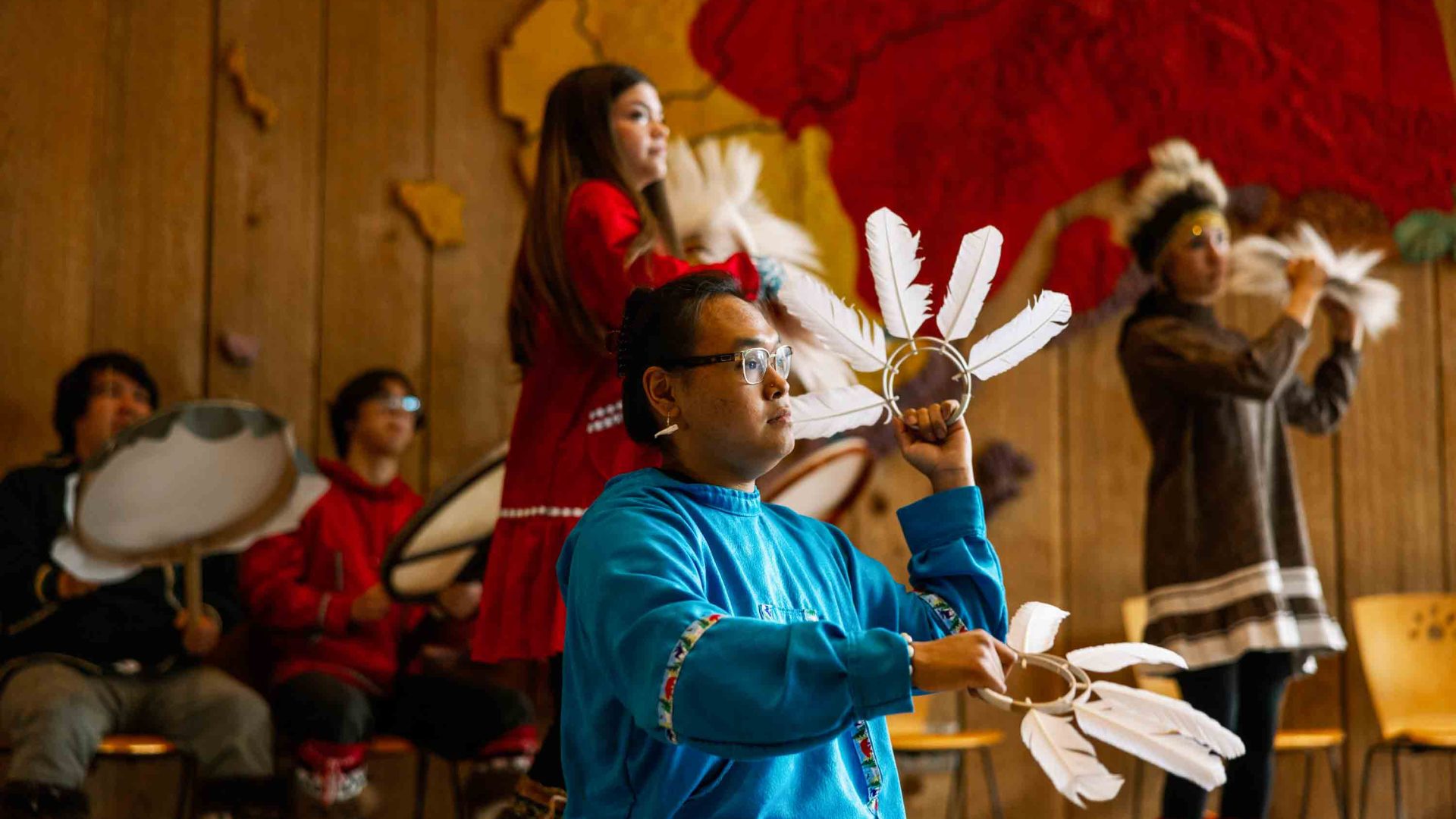 Indigenous performers use feathers to dance.