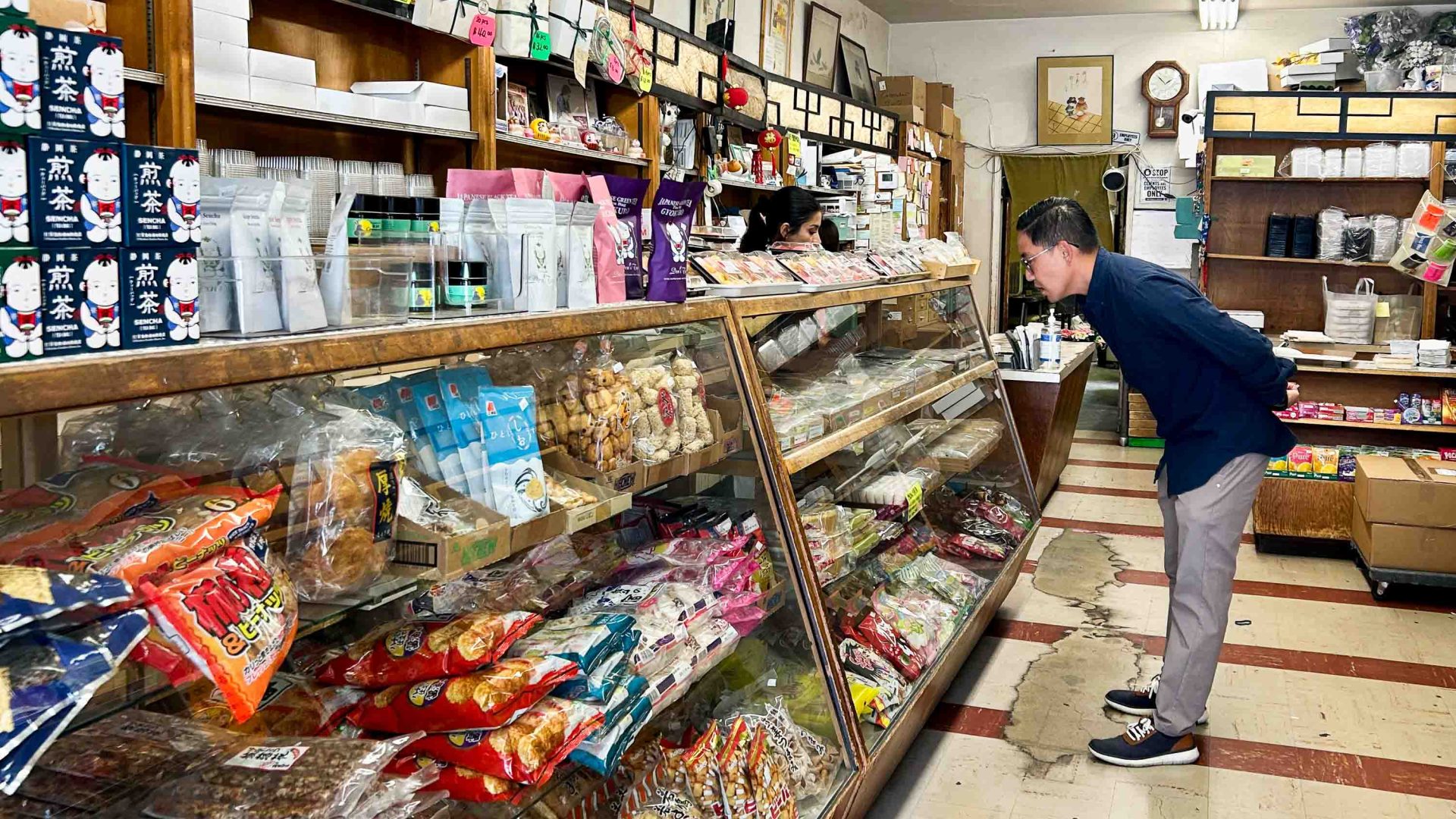 A man peers into a cabinet inside a store.