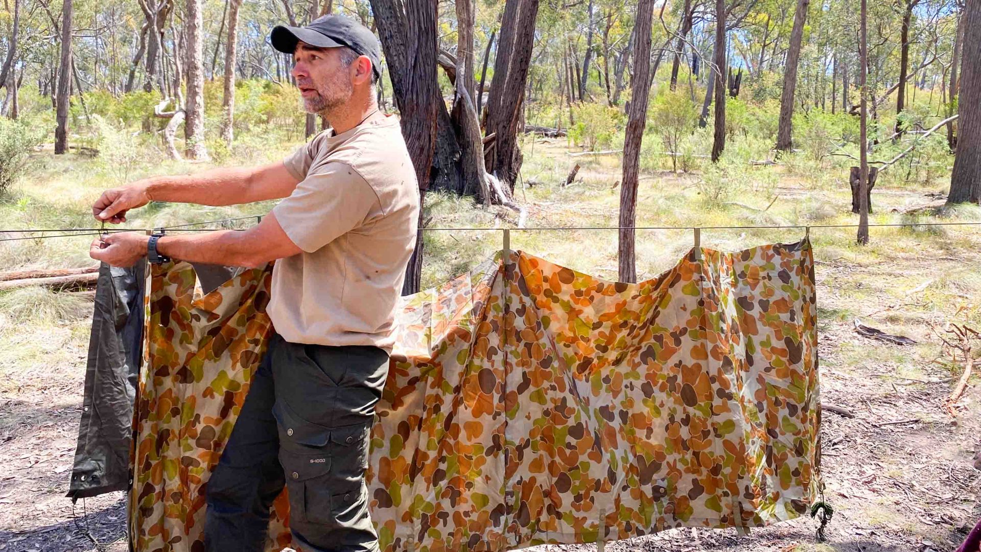 A man holds up a tarp.