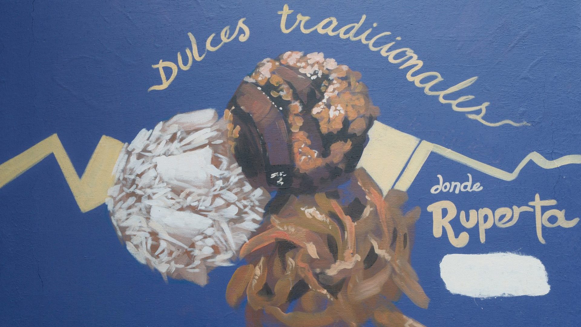 Handpainted blue wall with illustration of dessert balls, reading 'Dulces tradicionales, Dona Ruperta'