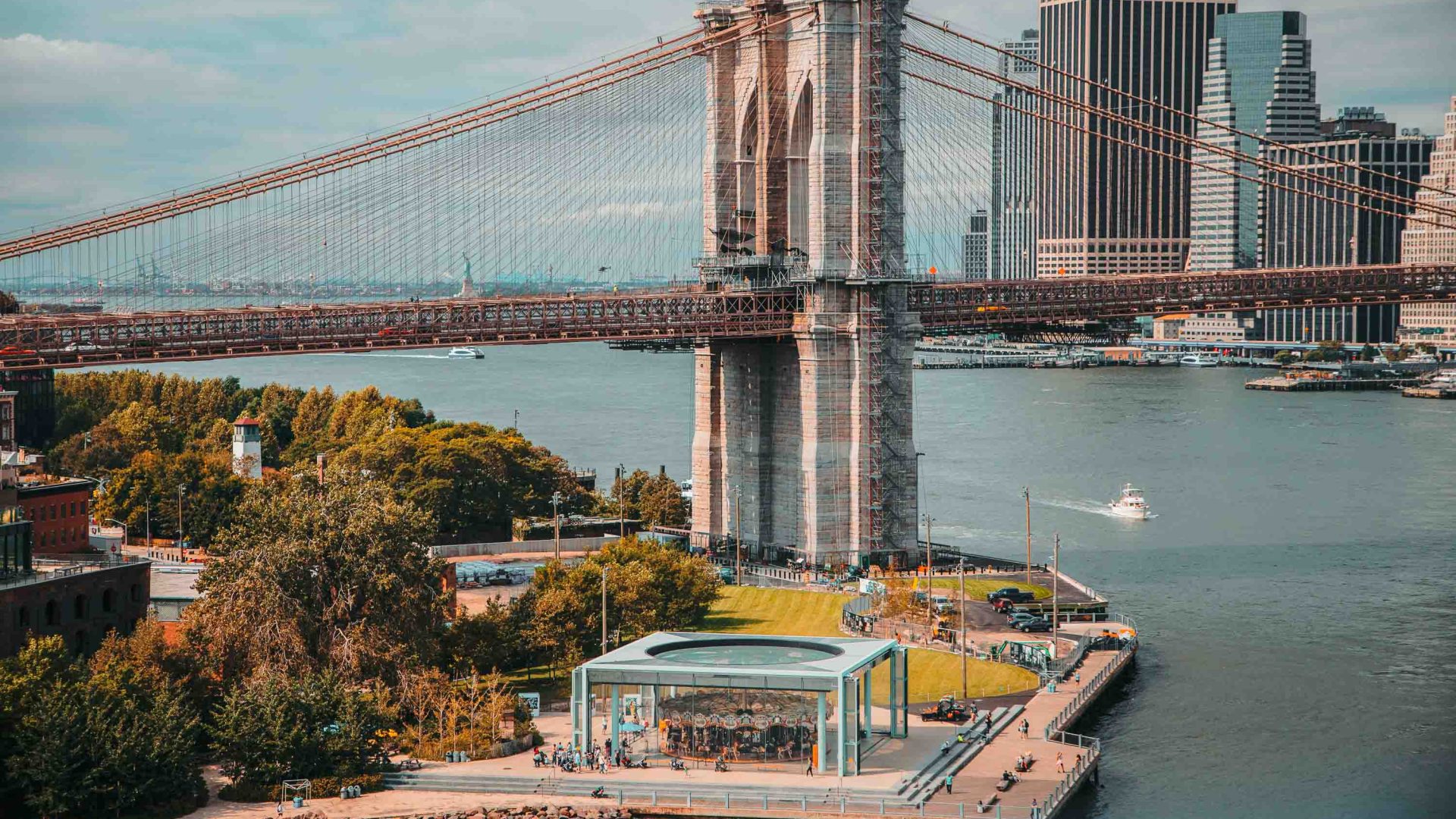 The Brooklyn Bridge with the east River and Dumbo carousel in the foreground.