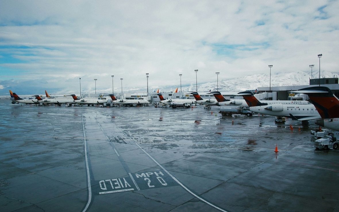 The tails of planes parked in a line at an airport.