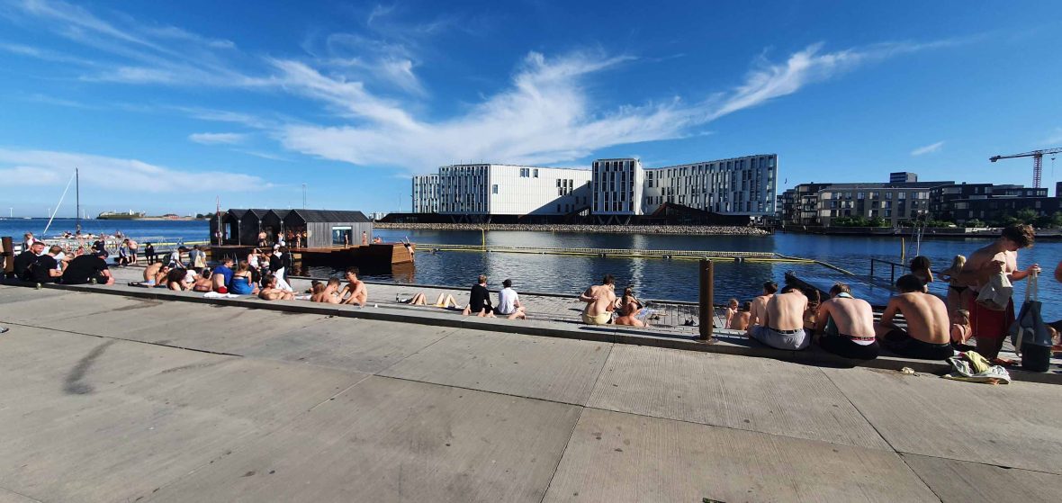 People sit by the edge of the river.
